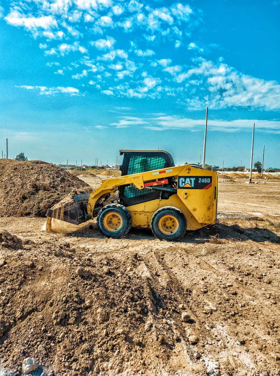 Skid steer performing final grade on a lot